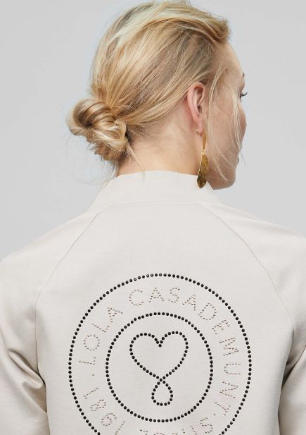 chaqueta estilo bomber en color crudo con estampado militar y detalle logo con cristales en espalda, de Lola Casademunt