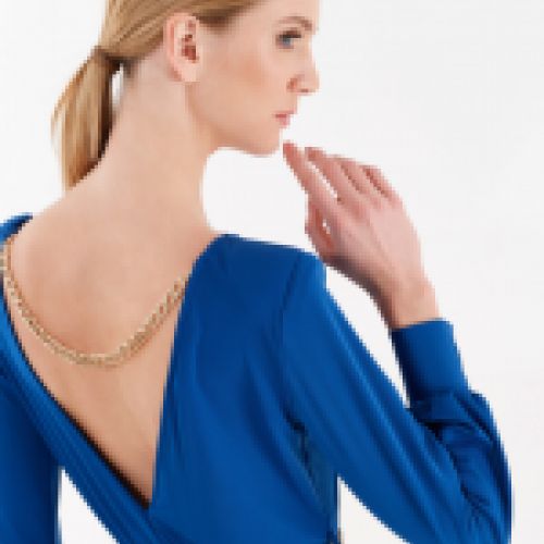 Vestido en color azul serenity con falda plisada, bajo asimétrico, detalle cadena dorada en espalda y cintura, de Rinascimento