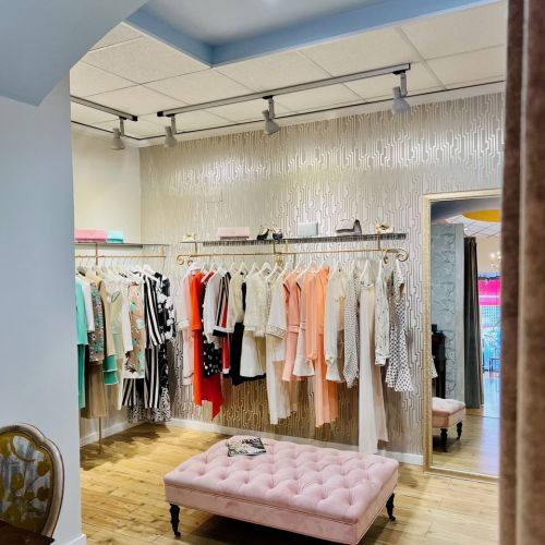 Tienda con burros de ropa y asiento mullido