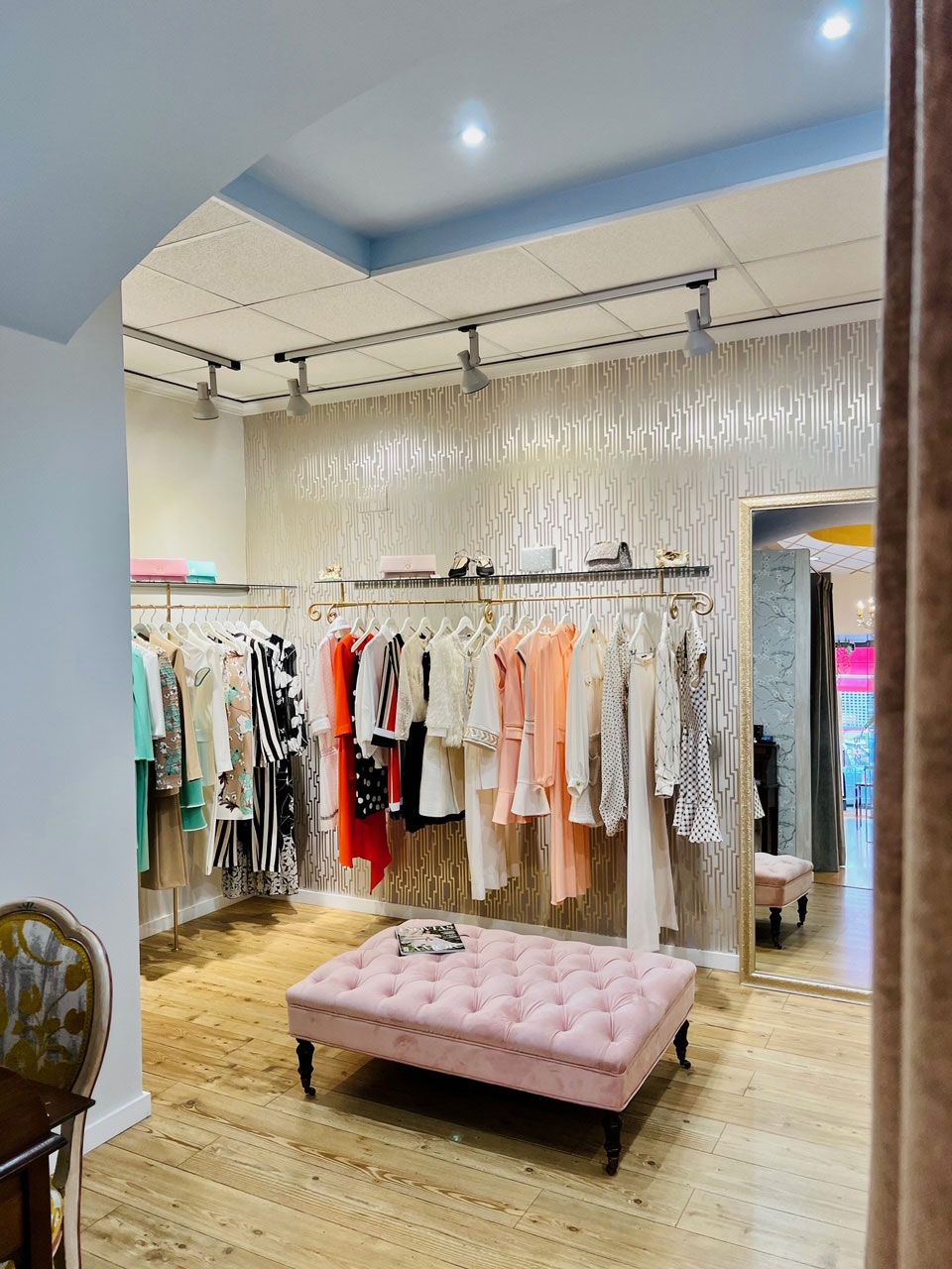 Tienda con burros de ropa y asiento mullido